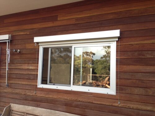 Acmeda Vue External Wire Guide blind installed over a sliding window