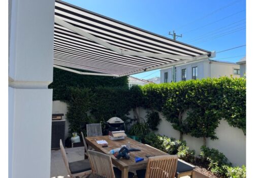 black and white striped folding arm retractable awning