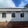Deck with wall-mounted awning on modern home exterior.