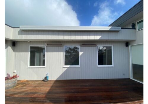Deck with wall-mounted awning on modern home exterior.