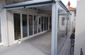 Custom clear PVC outdoor bistro blinds enclosing a residential timber deck and patio area in Geelong