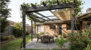 Dark timber pergola with a retractable fabric canopy and dining set by Pergolas Altona